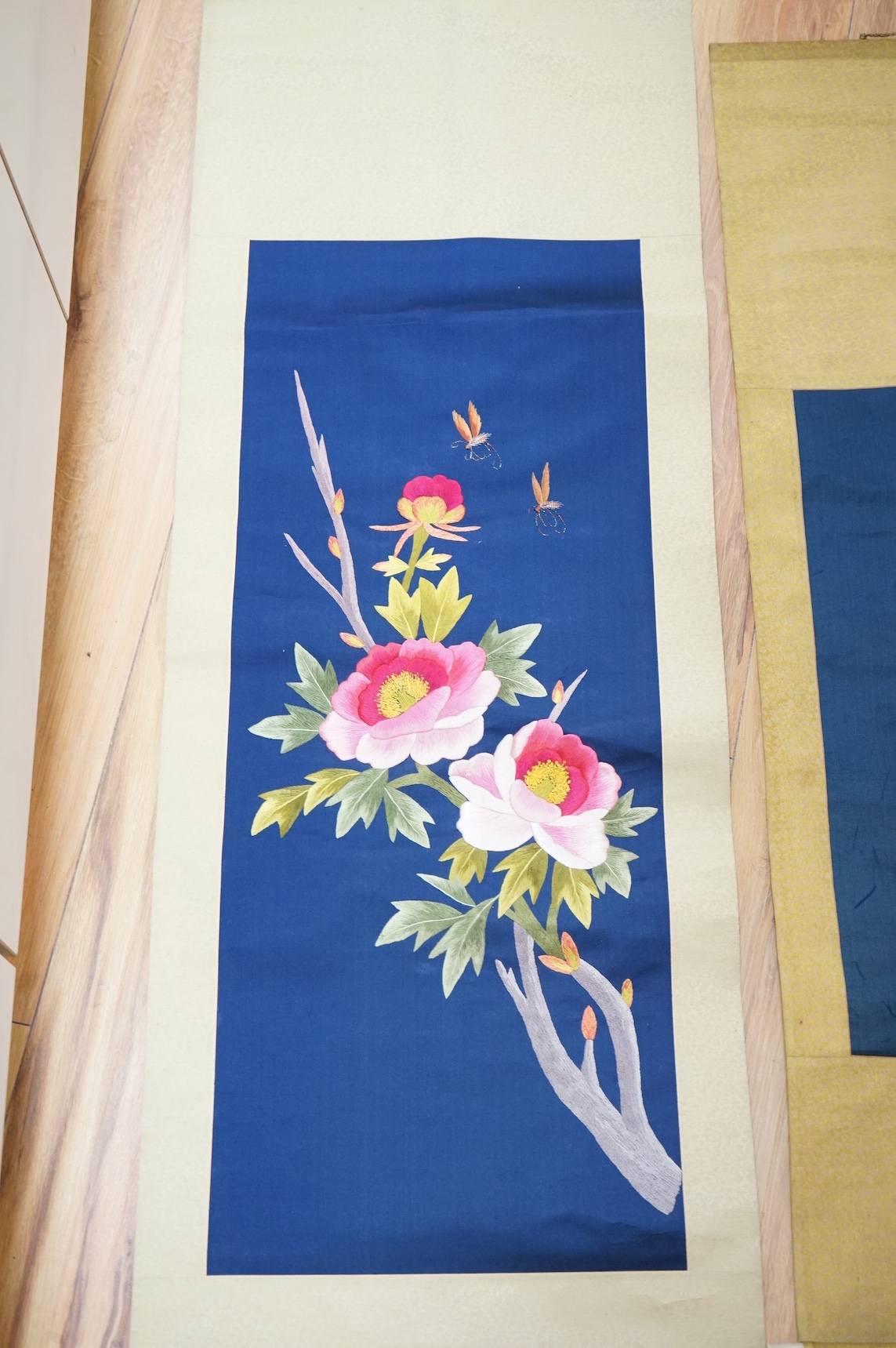 Two early 20th century Chinese embroidered silk scrolls to include one depicting flowers. Condition - fair/good